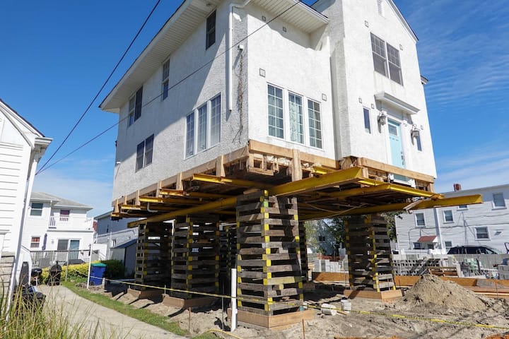 A team of professionals using specialized equipment to raise a house in Burleson, preparing it for elevation and renovation